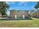 Large backyard with a brick home featuring two white doors and an outdoor grill at 3400 Barfield Dr, Charlotte, NC 28217