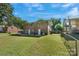 A fenced backyard featuring a well-maintained lawn and a brick two-story home at 3400 Barfield Dr, Charlotte, NC 28217