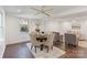 Open-concept living area with hardwood floors featuring a dining set, armchairs, and a ceiling fan at 3400 Barfield Dr, Charlotte, NC 28217