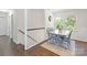 Bright dining area features hardwood floors, stairs to second floor, large windows and a dining table set for four at 3400 Barfield Dr, Charlotte, NC 28217