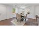 Bright dining area with hardwood floors, neutral-toned chairs, and windows offering natural light at 3400 Barfield Dr, Charlotte, NC 28217