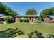 Charming brick home featuring a well-manicured lawn and a bright red front door at 3400 Barfield Dr, Charlotte, NC 28217