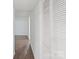 Hallway with hardwood floors, white walls, closet doors, and bright natural light at 3400 Barfield Dr, Charlotte, NC 28217