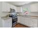 Bright kitchen featuring white cabinets, stainless steel appliances, and granite countertops at 3400 Barfield Dr, Charlotte, NC 28217