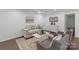 Comfortable living room with hardwood floors, neutral furniture, ceiling fan, and an area rug at 3400 Barfield Dr, Charlotte, NC 28217