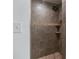 This bathroom has a shower with light brown and tan stone-look tiles and built-in shelving at 3400 Barfield Dr, Charlotte, NC 28217