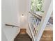 Staircase with hardwood steps and white railing leads to a bright dining area with a large window at 3400 Barfield Dr, Charlotte, NC 28217