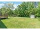 Lush backyard with a wooden deck and storage shed at 3932 Slagle Dr, Charlotte, NC 28215