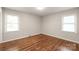 Cozy bedroom features hardwood floors, neutral paint, and two windows at 3932 Slagle Dr, Charlotte, NC 28215