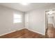 This bedroom has neutral paint, hardwood floors, a window, and a door to the hallway at 3932 Slagle Dr, Charlotte, NC 28215
