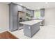 Bright kitchen featuring stainless steel appliances, gray cabinets, a center island, and new flooring at 3932 Slagle Dr, Charlotte, NC 28215