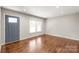 Bright living area with hardwood floors, new front door, large window, and fresh paint throughout the space at 3932 Slagle Dr, Charlotte, NC 28215
