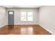 Well-lit living room features hardwood floors, a large window, and updated gray paint at 3932 Slagle Dr, Charlotte, NC 28215