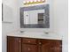 Bathroom with double sink vanity with dark wood cabinets and a decorative, illuminated mirror at 4001 Carmel Acres Dr, Charlotte, NC 28226