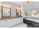 Bathroom with dual sinks, granite countertops, and a soaking tub at 4001 Carmel Acres Dr, Charlotte, NC 28226