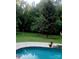 Relaxing in-ground pool featuring a stone surround and a lush green backyard, perfect for outdoor entertaining at 4001 Carmel Acres Dr, Charlotte, NC 28226