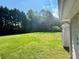 A spacious backyard featuring a green lawn with mature trees, ideal for outdoor activities at 401 Overlook Dr, Monroe, NC 28110