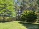 Beautiful backyard featuring a green lawn with mature trees and lush, mature trees at 401 Overlook Dr, Monroe, NC 28110