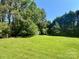View of the backyard with a well-maintained lawn and lush, mature trees at 401 Overlook Dr, Monroe, NC 28110