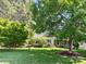 Scenic view of a house nestled among mature trees and a lush green lawn at 401 Overlook Dr, Monroe, NC 28110