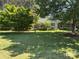Landscaped front yard featuring a green lawn with mature trees and a small house at 401 Overlook Dr, Monroe, NC 28110