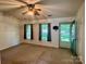 Bright living room with a ceiling fan, neutral carpeting, and an exterior door at 401 Overlook Dr, Monroe, NC 28110