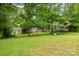 Spacious backyard with lush greenery, mature trees, basketball court, and swing set at 408 Idlewood Dr, Kannapolis, NC 28083