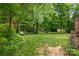 Spacious backyard with lush greenery, mature trees, and swing set at 408 Idlewood Dr, Kannapolis, NC 28083