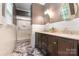 Bright bathroom featuring dual sinks, marble floors, tiled walls, and a glass-enclosed shower at 408 Idlewood Dr, Kannapolis, NC 28083