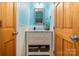 Charming bathroom with blue walls, white vanity with marble top, and wooden doors at 408 Idlewood Dr, Kannapolis, NC 28083