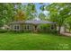 Charming single-story home with green lawn, mature trees, and inviting front porch at 408 Idlewood Dr, Kannapolis, NC 28083