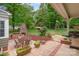 Backyard patio with brick fireplace, pavers, patio furniture, and lush landscaping at 408 Idlewood Dr, Kannapolis, NC 28083