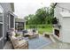 Relaxing patio area showcasing a brick fireplace with TV, outdoor seating, and a view of the yard at 4174 Charlton Rd, Fort Mill, SC 29715