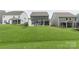 View of the property's backyard and patio featuring an outdoor fireplace and seating area, green space and privacy at 4174 Charlton Rd, Fort Mill, SC 29715