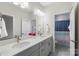 Bright bathroom featuring a double sink vanity with gray cabinets, modern fixtures, and a linen closet at 4174 Charlton Rd, Fort Mill, SC 29715
