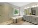 Bright bathroom featuring a glass shower, tub, and double vanity with modern fixtures at 4174 Charlton Rd, Fort Mill, SC 29715