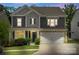 Charming two-story home with a stone-accented garage and inviting front porch at dusk at 4174 Charlton Rd, Fort Mill, SC 29715