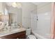 Well-lit bathroom with granite countertop, dark wood vanity, and a combined tub and shower with white surround at 4313 Courtly Ln, Belmont, NC 28012