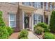 Attractive brick townhome featuring a decorative front door, black shutters, and manicured landscaping at 4313 Courtly Ln, Belmont, NC 28012