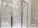 Modern shower stall featuring white marble tiles, a glass door, and a rain shower head at 4313 Courtly Ln, Belmont, NC 28012