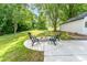 Landscaped backyard featuring a fire pit with seating, surrounded by lush greenery and mature trees at 437 Chadmore South Dr, Charlotte, NC 28270