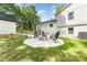 Backyard with a fire pit, seating, lush green lawn, and well-maintained landscaping at 437 Chadmore South Dr, Charlotte, NC 28270