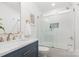 Bright bathroom with marble countertop, navy vanity, and a glass-enclosed shower over tub at 437 Chadmore South Dr, Charlotte, NC 28270