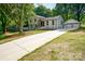 Charming exterior of a modern home with a long driveway and detached garage nestled among mature trees at 437 Chadmore South Dr, Charlotte, NC 28270