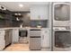 Modern kitchen featuring herringbone backsplash, stainless steel appliances, and in-unit washer and dryer at 437 Chadmore South Dr, Charlotte, NC 28270