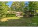 The backyard features a pergola, a deck with furniture, mature trees, and a lush lawn at 4424 Huntington Dr, Gastonia, NC 28056
