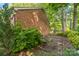 Landscaped backyard with trees and shrubs. The home has brick siding and a wooden deck at 4424 Huntington Dr, Gastonia, NC 28056