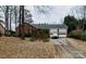 Charming one-story brick home with a two-car garage and mature trees on a leaf-covered lawn at 4424 Huntington Dr, Gastonia, NC 28056