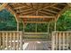 Wooden gazebo featuring a built-in bench and wood floors, surrounded by lush greenery at 4424 Huntington Dr, Gastonia, NC 28056