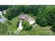 Aerial view of a sprawling property with a long drive, surrounded by lush greenery and mature trees at 4616 Gold Finch Dr, Denver, NC 28037